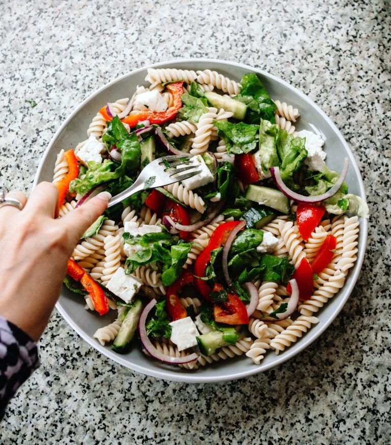 Greek-style pasta salad with fusilli, cucumber, peppers, red onion and feta; illustrative photograph